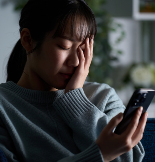 Woman distressed over defamatory messages on mobile phone, illustrating defamation concerns