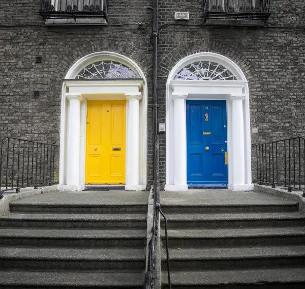 Two neighbouring front doors, one blue and one yellow, representing neighbour disputes in Scotland