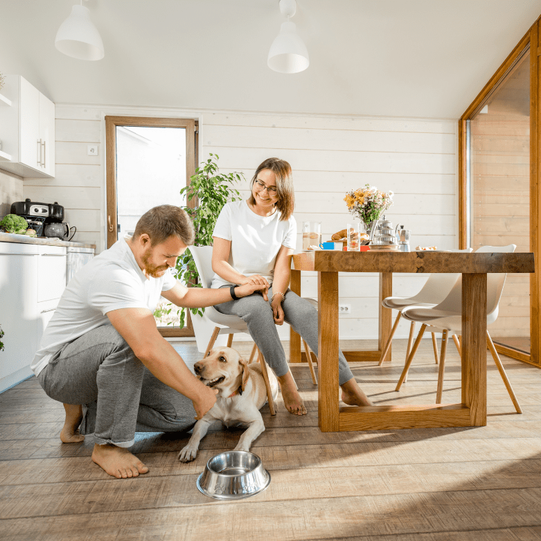 Young couple with a dog at a dining table, representing first-time home buyers in Scotland