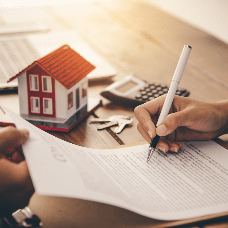 Calculator, documents, and model house on a table, symbolising mortgage discharge in Scotland