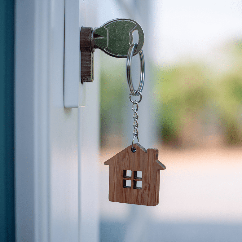 House key in a door with a house-shaped keyring, symbolising homeownership and property purchase in Scotland
