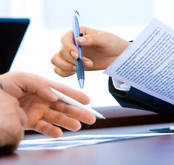 Person signing a commercial contract agreement during business negotiations