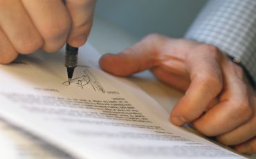 Man's Hands Signing Document --- Image by © Royalty-Free/Corbis