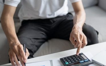 Man reviewing financial figures with a calculator while planning for Inheritance Tax changes and estate planning