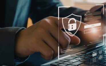 Man typing on a laptop with padlock overlay representing AML and source of funds checks when buying a home in Scotland
